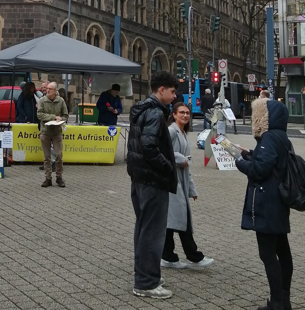 Foto vom Neumarkt: Menschen vom Friedensforum und Passanten im Gespräch, im Hintergrund der Info-Stand